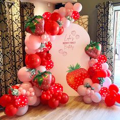 the balloon arch is decorated with strawberrys and balloons