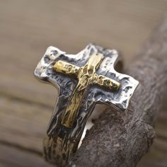 When selecting a gift of faith, you cannot go wrong with this sterling silver and gold cross ring for men or women. Custom handcrafted in the finest detail, this precious cross ring is a unique accessory that is stunning when worn. The surface of the ring features an oxidized texture 17mm wide on top with a handcrafted 14KT solid gold cross on it. The width of the band is 6mm. You may add a more personal feeling with a short engraved by hand message on the inside. We free standard worldwide deli Spiritual Cross Shaped Rings For Gift, Gold Sterling Silver Cross Ring, Gold Cross Rings In Sterling Silver, Handmade Cross Ring As A Gift, Handmade Cross Ring For Gift, Handmade Cross-shaped Ring For Gifts, Handmade Cross-shaped Ring As Gift, Handmade Cross Rings As Gifts, Hand Message