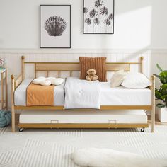 a bedroom with two pictures on the wall and a teddy bear sitting on the bed