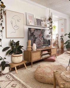 a living room with plants and pictures on the wall