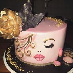 there is a pink cake with gold decorations on it and a rose in the middle