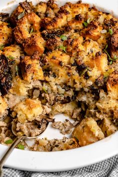 a casserole dish filled with stuffing and topped with a serving utensil