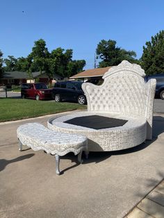 a white bed sitting in the middle of a driveway