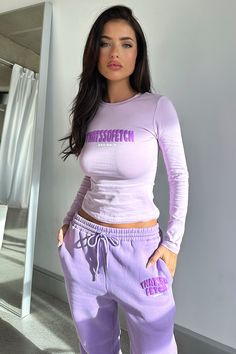 a woman in purple sweatsuit posing for the camera