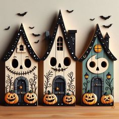 three wooden houses decorated with pumpkins and bats