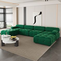 a large green couch sitting in a living room next to a white table and window