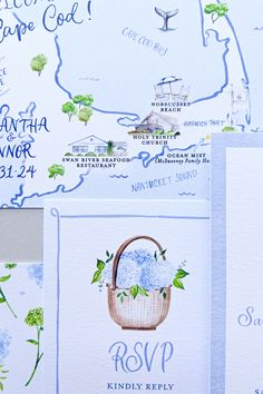 the wedding stationery is laid out on top of each other, with blue flowers in a basket