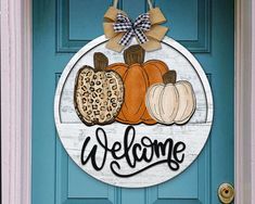 a welcome sign hanging on the front door of a house with leopard print pumpkins and cheetah