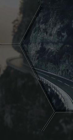 an aerial view of a highway with trees and mountains in the background