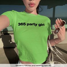 "365 Party Girl Charli XCX Brat" Graphic Slogan Printed On Aesthetic Retro Vintage 90s Y2k Baby Tee Shirt with our own unique font.  🎨 Available in White, Light Pink, Light Blue, Navy, Black. If you need a different color, please let us know! (Ash, Red, Sport Grey & Green)  🎁 Our baby tees are perfect gift for her or him offering timeless fashion and versatility that anyone will cherish. Baby tees, popular in the '90s, have short sleeves and a slightly cropped body, giving a flattering feminin Y2k Fitted T-shirt For Concert, Stretch T-shirt With Letter Print For Party, Fitted Rave T-shirt For Streetwear, Y2k Short Sleeve Club T-shirt, Y2k Club Tops With Letter Print, Y2k Letter Print Tops For Club, Y2k Style Letter Print Tops For Club, Y2k Style Tops For Spring Concert, Green Y2k Style Top For Club