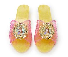 a pair of princess slippers on top of a white surface next to each other