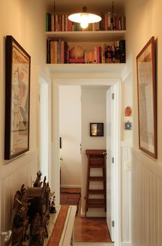 an entry way with bookshelves and pictures on the wall above it in a home