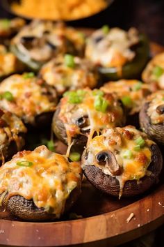 stuffed mushrooms with cheese and green onions on a wooden platter, ready to be eaten