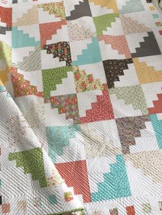 a colorful quilt is laying on top of a bed sheet that has been made into a blanket