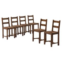 a set of six wooden chairs sitting next to each other