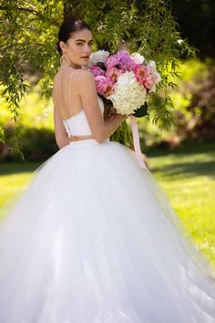 a woman in a wedding dress holding flowers