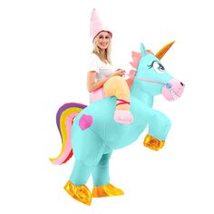 a woman riding on the back of a blue and pink unicorn inflatable costume