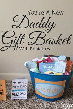 a blue bucket filled with cards next to a sign that says, you're a new daddy gift basket with printables