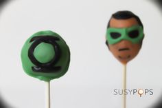 two lollipops with green and black decorations on them, one has a man's face