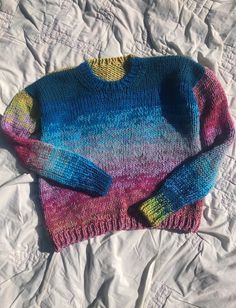 a colorful sweater laying on top of a bed