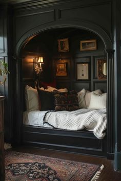 a bed in a room with dark wood paneling and lots of pillows on it