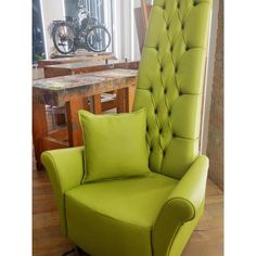 a green chair sitting in front of a wooden table