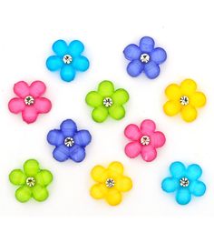 small plastic flowers with crystal centers in various colors and sizes, set on a white background