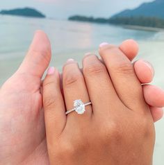 two people holding each other's hands on the beach