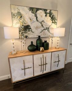 a white and gold sideboard with two vases on it