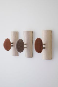 three wooden pegs are mounted to the wall