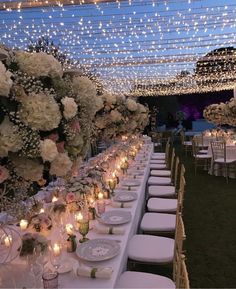 a long table is set up with white and pink flowers, candles, and plates