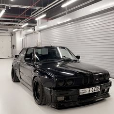 a black bmw is parked in a garage