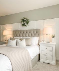 a white bed sitting next to two lamps on either side of the headboard and foot board