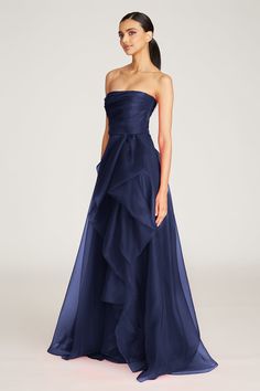 Our bestselling Teresa gown is back in a navy colorway. It's sculpted in pebble organza — a weightless and high-quality fabric woven to give your style movement and bounce. This radiant piece comes strapless and features a draped bodice, front slit accent, and a cascading ruffled skirt. Click here for all available colors. Strapless Neckline A Line Silhouette Non-Stretch Floor Length REF: 8817572 Monte Carlo Dresses, 2 Peice Dress, Classy Formal Dresses Long, Deep Blue Gown, Prom Dresses 2025 Trends, Classy Black Tie Dress, Floor Length Evening Gowns, Winter Formal Gown, Steel Blue Prom Dress