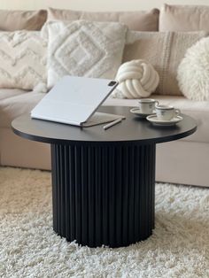 a coffee table with two cups and a laptop on it