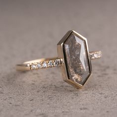 a close up of a ring with a stone in the middle and diamonds around it