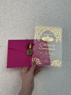 a person holding a pink and gold wedding card