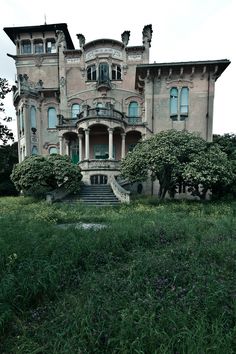 an old house with many windows and bushes