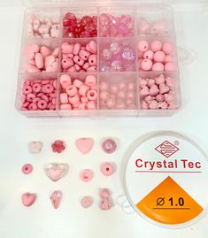 a plastic container filled with lots of pink and white beads next to a sign that says crystal tec