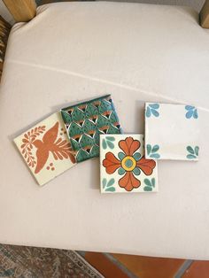 four ceramic tiles sitting on top of a white chair