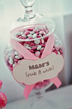 pink and white candies in a glass bowl with a name tag on the front