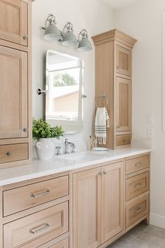 a white sink sitting under a bathroom mirror next to a wooden cabinet and counter top