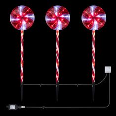 three red and white lights in the shape of candy canes on a black background