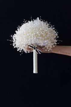 a hand holding a bunch of white flowers