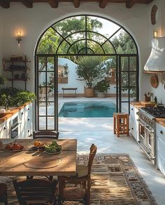 a kitchen with an arched doorway leading to the swimming pool and outdoor dining room area