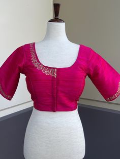 Hot Pink Color with slight tint of orange Raw Silk Readymade Blouse with beautiful Stone Handwork. Item : Readymade Blouse Ready-to-Wear : Yes Size : 36 (Can be opened to Size 40) Color : Hot Pink with a slight tint of Orange  Blouse Fabric : Soft Silk  Lining : Yes, it is fully lined  Padded or Non-Padded : Padded Closure: Front Closure with hooks. Disclaimer - :  -This is a Standard Size blouse. We do not guarantee perfect fit as every body and shape is different. Little or no alteration would Elegant Short Sleeve Top With Resham Embroidery, Elegant Pink Blouse With Pallu Detail, Pink Bollywood Silk Blouse, Elegant Short Sleeve Top With Self Design, Festive Short-sleeve Blouse Piece, Fitted Resham Embroidery Top With Short Sleeves, Fitted Tops With Resham Embroidery And Short Sleeves, Pink Silk Long Sleeve Blouse Piece, Long Sleeve Pink Silk Blouse