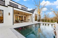 a house with a swimming pool in front of it and an open patio area to the side