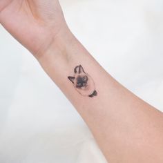 a small cat tattoo on the wrist