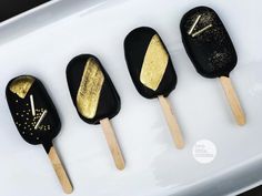 four popsicles with gold and black designs on them