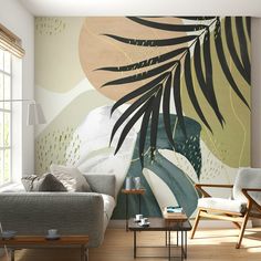 a living room scene with focus on the sofa and wallpaper that has palm leaves painted on it